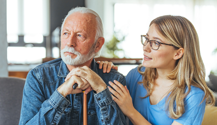 Female professional doctor touching shoulder comforting upset senior patient having geriatric disease expressing trust, support concept. Geriatrician helping lonely elderly crying man. Close up view