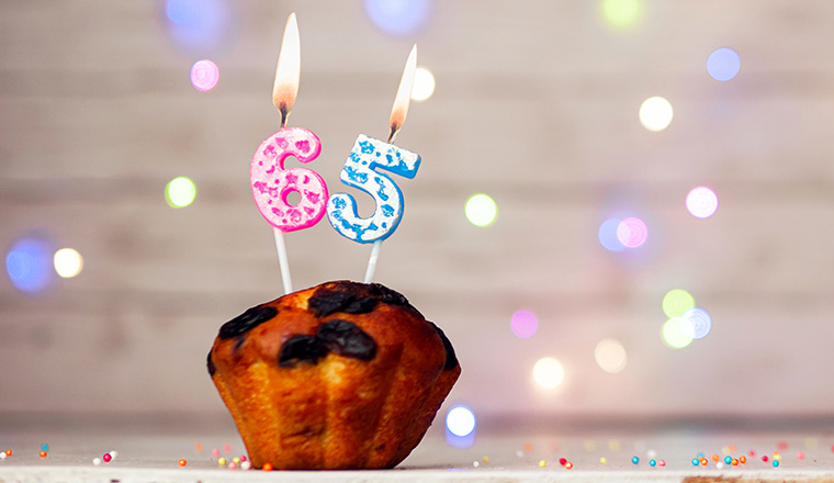 Happy birthday background with muffin and number of candles on light bulbs bokeh background. Greeting card happy birthday copy space with number 65