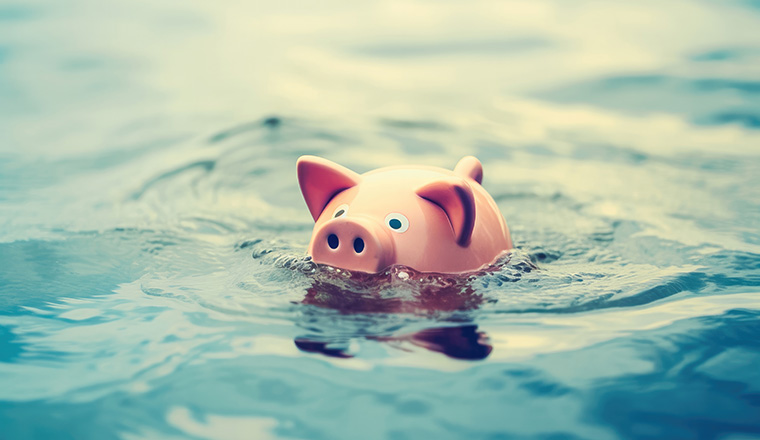 Piggy bank floating on flood water.