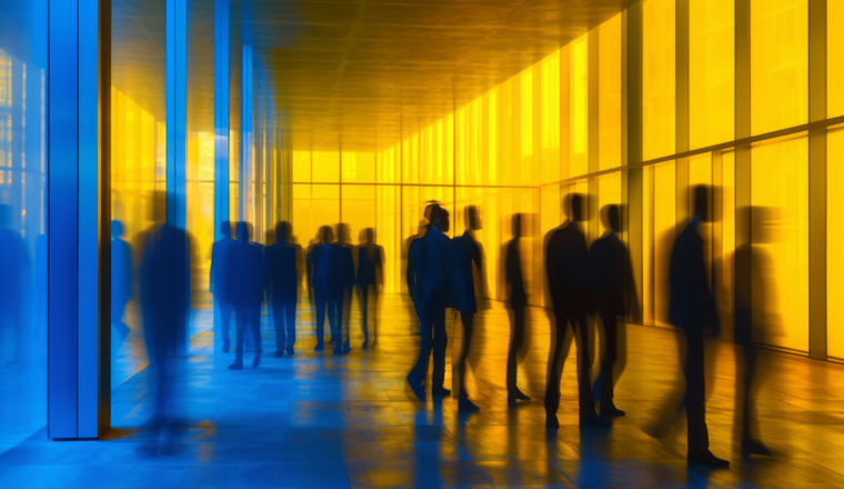 People walking in a hallway with a blue light that is lit up.