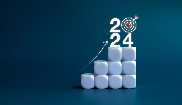 2024 year number with target icon and rise up arrow on white blocks as a graph steps on blue background. New year trends, action plan, profit, business growth process, economic improvement concepts.