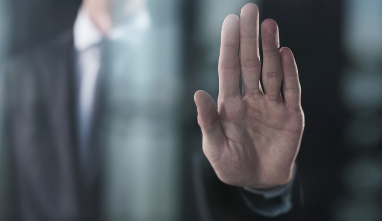 Man's hand shows a palm on a dark background