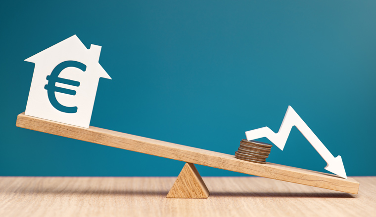 Reducing the interest rate on mortgages in the Europe. Reducing the cost of a loan for real estate or rental housing. Model of a house with a Euro symbol on the scales. High quality photo