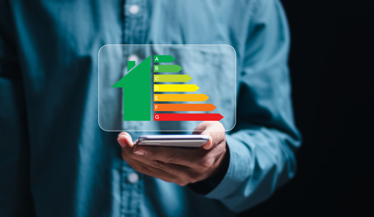 Energy efficiency concept. Person use smartphone with virtual screen of energy efficiency rating for energy efficient house building rate label audit.