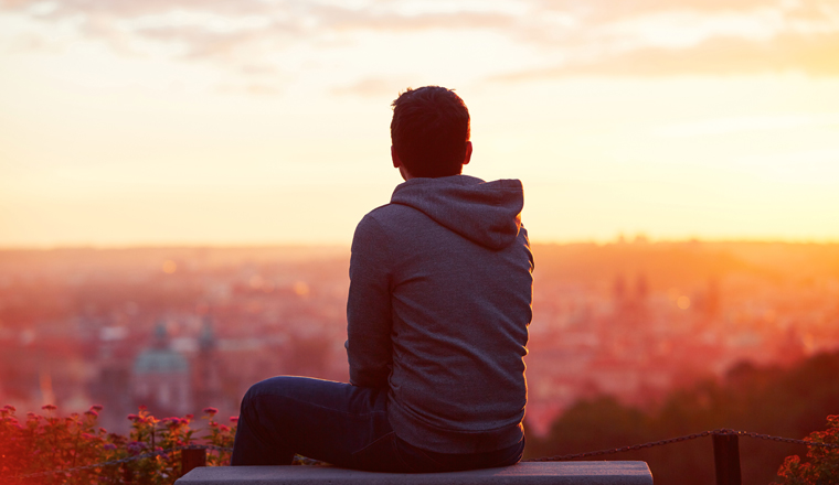 Young man is looking at the sunrise.