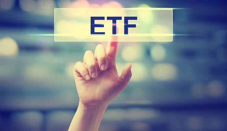 ETF - Exchange Traded Fund concept with hand pressing a button on blurred abstract background 