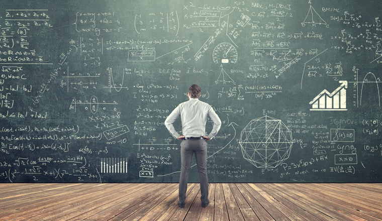 Student studying math on the blackboard full of formulas