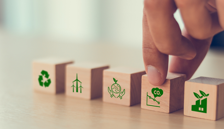 Net zero and carbon neutral concept. Net zero greenhouse gas emissions target. Climate neutral long term strategy. Hand put wooden cubes with decrease carbon emission icon and green icon. Green banner
