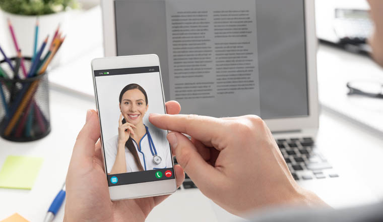 Doctor with a stethoscope on the smartphone screen. Telemedicine or telehealth concept.