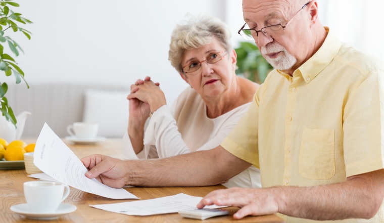 Elderly couple calculating costs of household. Senior people with low pension