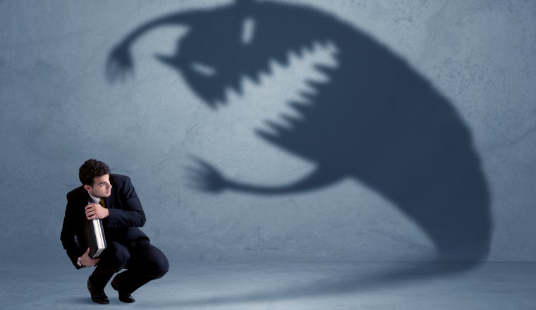 Business man afraid of his own shadow monster concept on grungy background