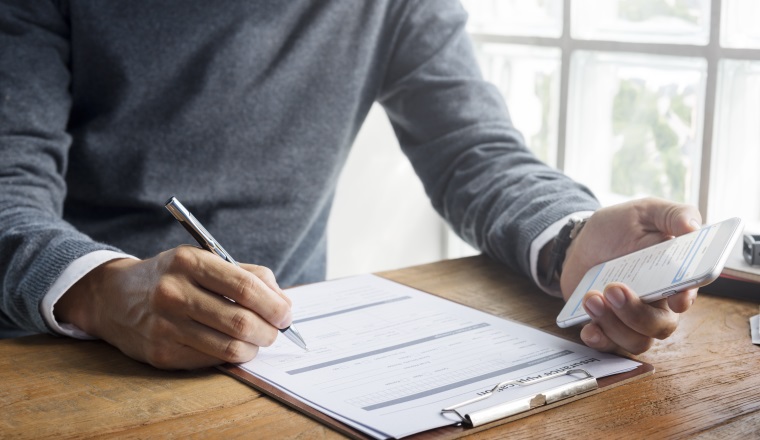 Man Writing Insurance Application Form Concept