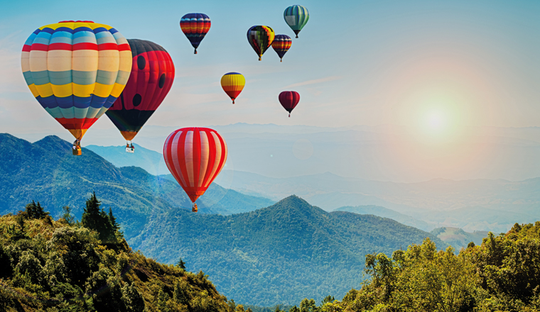 Beautiful view of mountain with hot air balloons on morning at Thailand.