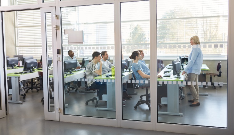 Dozentin unterrichtet Studenten im Computerkurs an der Universität