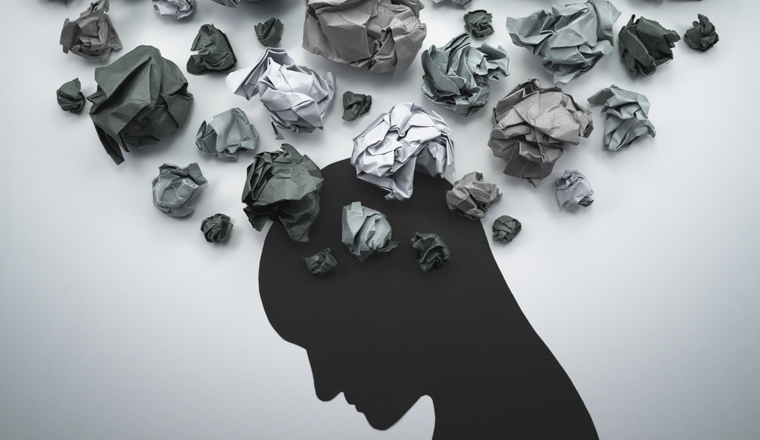 Silhouette of troubled person head. Concept image of anxiety and negative emotion. Waste paper and head silhouette. 