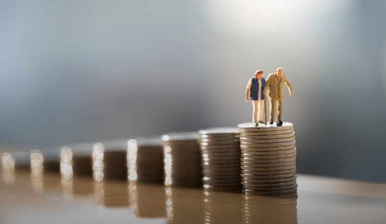 Concept of retirement planning. Miniature people: Old couple figure standing on top of coin stack.