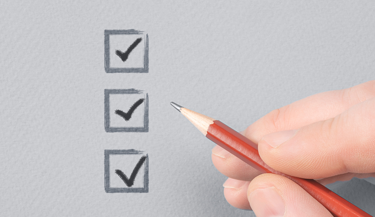 hand with pencil writing check mark on Checklist. Hand with pencil and check boxes on gray paper background. Male hand choosing three of three options.
