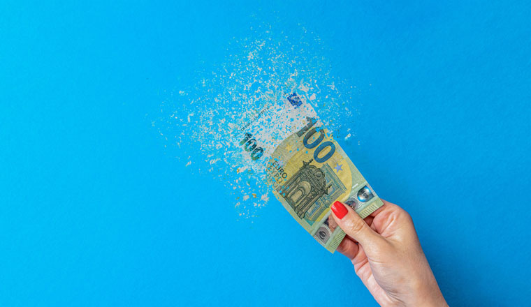 Euro inflation. Inflation in Europe, hyperinflation. Banner with blue background. One hundred euro banknote sprayed in the hand of a man on a blue background