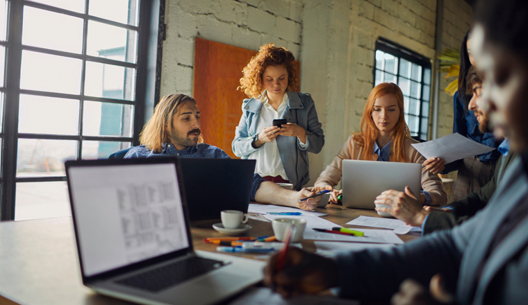 Young and diverse group of coworkers working on a project and having a meeting in a startup company office