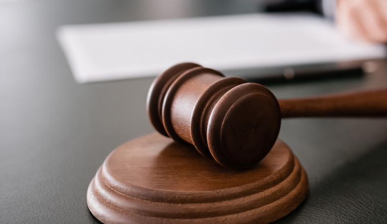 wooden gavel on desk near cropped judge on blurred background, banner