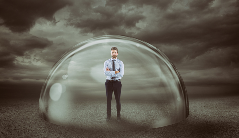 Businessman inside a transparent sphere that protects him.