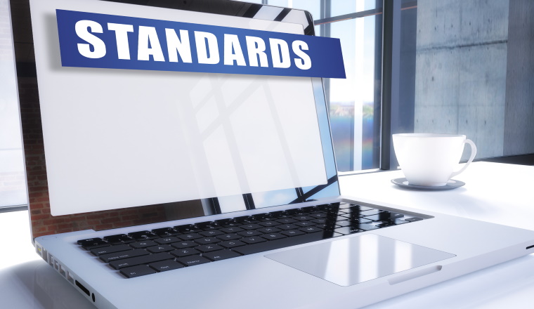 Standards text on modern laptop screen in office environment. 3D render illustration business text concept.
