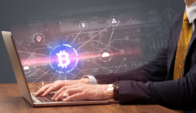 Hand checking on laptop global bitcoin exchange rate concept