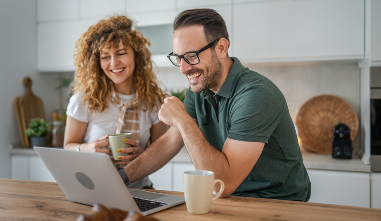 happy couple caucasian adult man and woman husband and wife morning routine use laptop computer during breakfast at home bright photo copy space