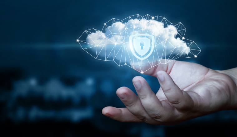 Hand shows a data cloud with a protective shield. The concept of data protection