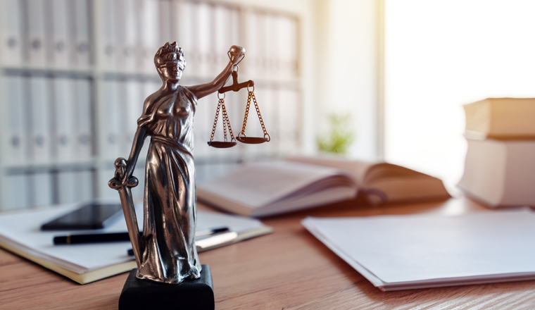 Lady Justice statue in law firm attorney office, blindfolded Justitia with balance scales and sword is personification of moral force in judicial system