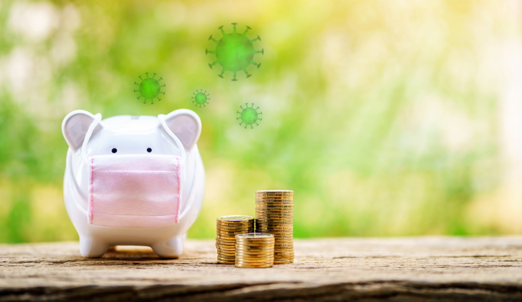 Sick piggy bank wearing surgical mask to prevent viruses and diseases put beside three stack gold coin put on the wood on sunlight in the public park, saving money for buy health insurance concept.
