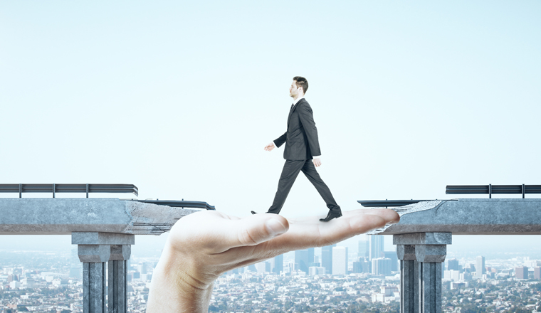 Businessman walking over gap in bridge on megapolis city view background. Business and challenge concept.