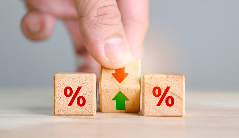 Interest rate financial and mortgage rates concept. Hand flip wood cube change arrow down to up