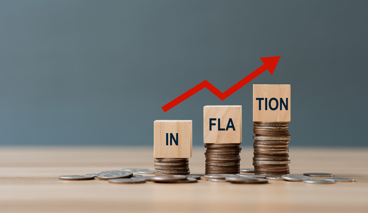 INFLATION word on a wooden cube on coins in idea for FED consider interest rate hike, world economics, and inflation control, US dollar inflation