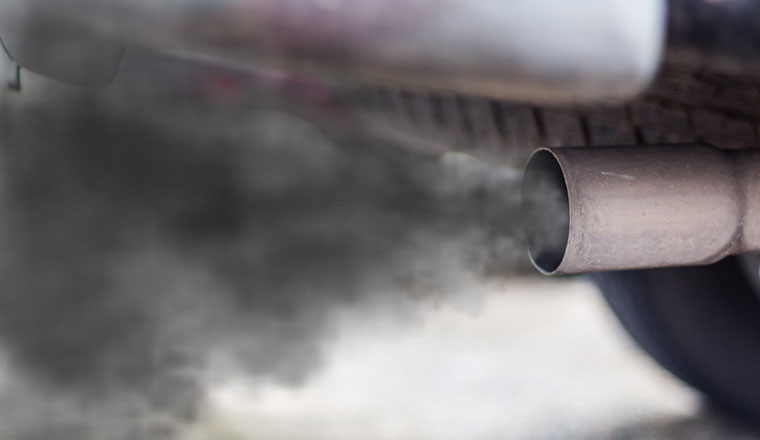 combustion fumes coming out of car exhaust pipe