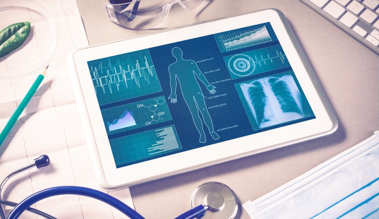 White tablet pc and doctor tools on gray surface