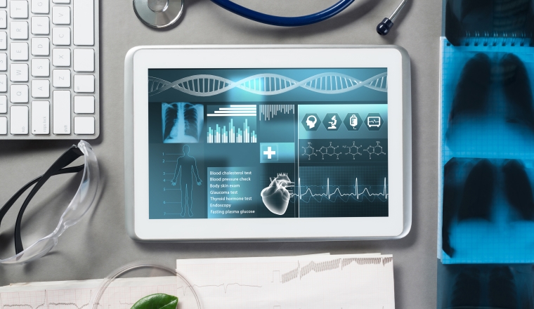 White tablet pc and doctor tools on gray surface