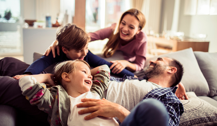 Happy young family relaxing on the couch together at home