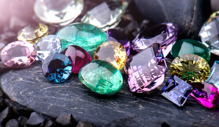 Gemstones collection jewelry set photo with black stone and dark lighting.