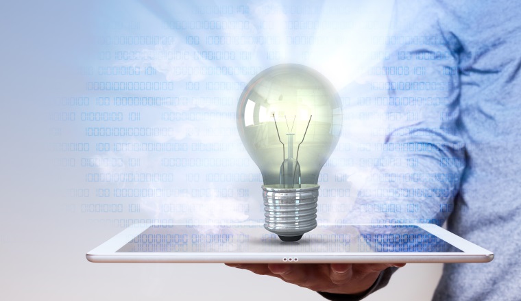 Human hand with tablet pc and idea bulb with bits.