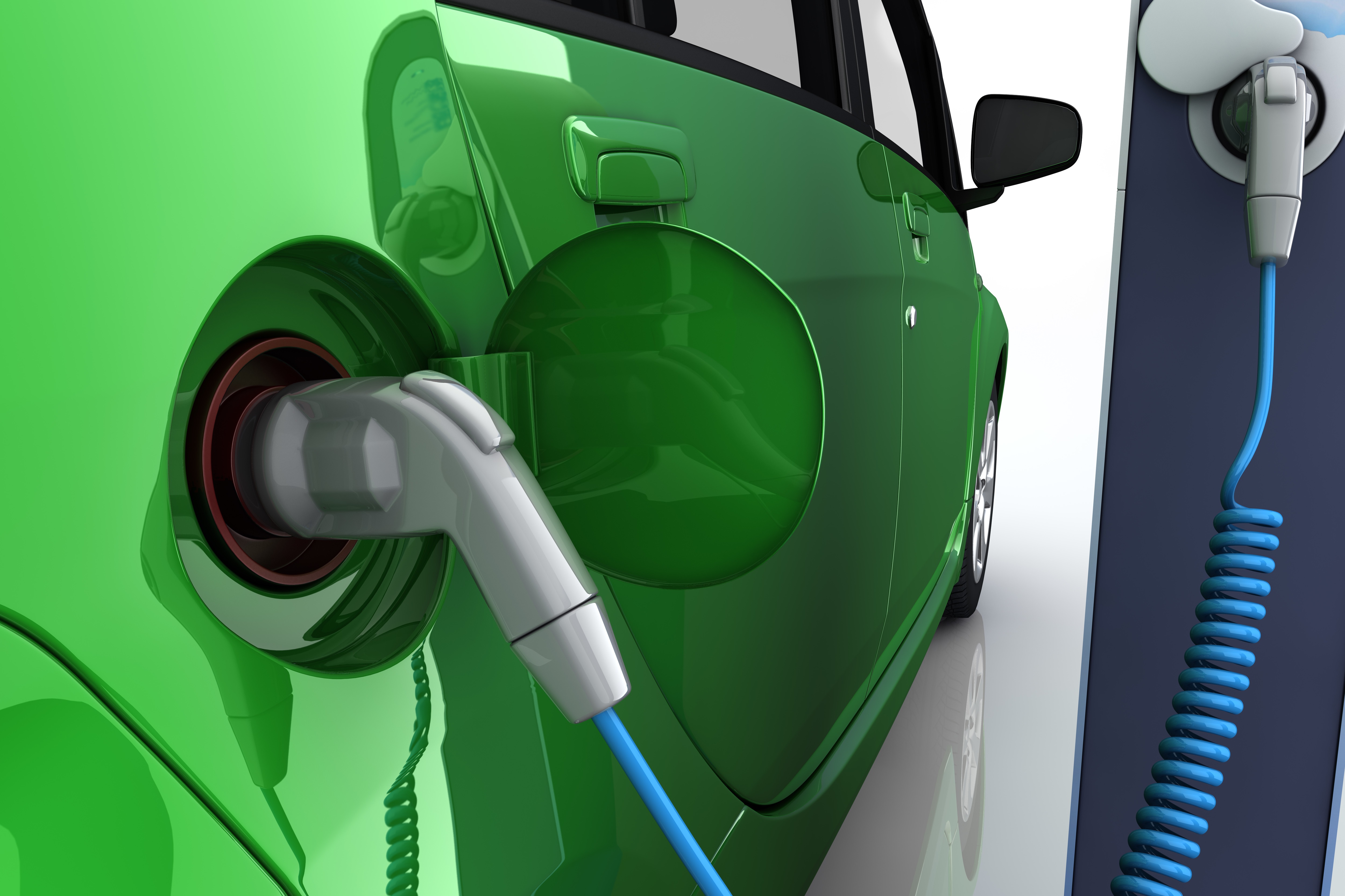 Grünes Elektroauto an der Ladestation einer Tankstelle mit Stromkabel