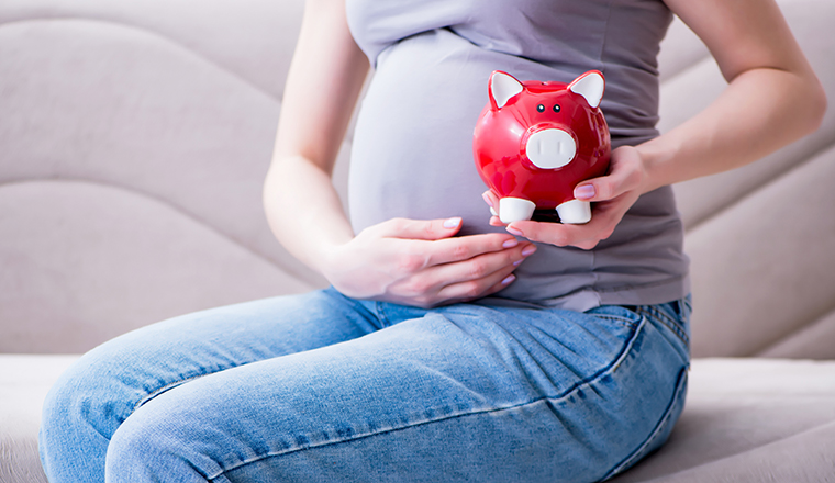 Pregnant woman with a belly tummy sitting on a sofa at home