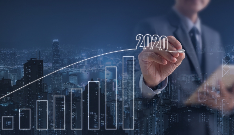 2020 Business Goals, Growth success, real estate development. Double exposure of businessman with digital tablet computer touching on virtual screen and the city with progress of positive business indicator