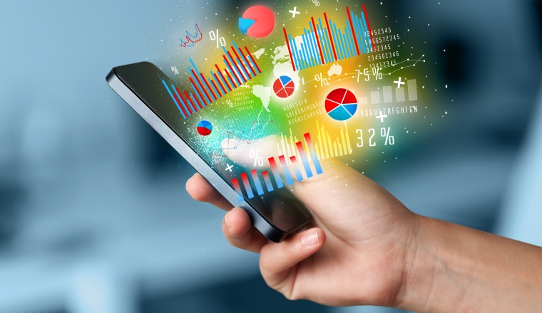 Business man holding smartphone with chart symbols concept