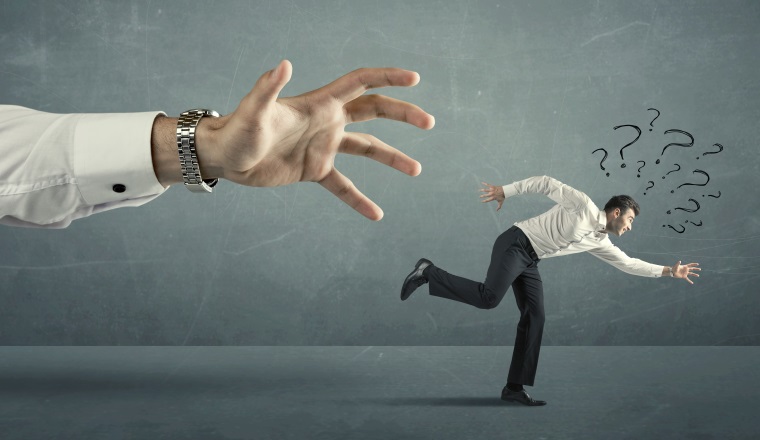 Businessman with question marks running away from a big hand concept on background