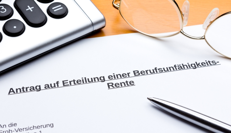 Antrag auf Erteilung einer Rente bei Berufsunfähigkeit mit Taschenrechner, Brille und Stift, Kuli