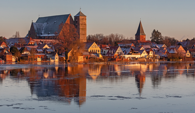 Verden an der Aller in Niedersachsen, Deutschland mit dem Dom bei starkem Hochwasser. Die Gebäude spiegeln im Wasser mit Eisschollen. Am 10. Januar 2024.