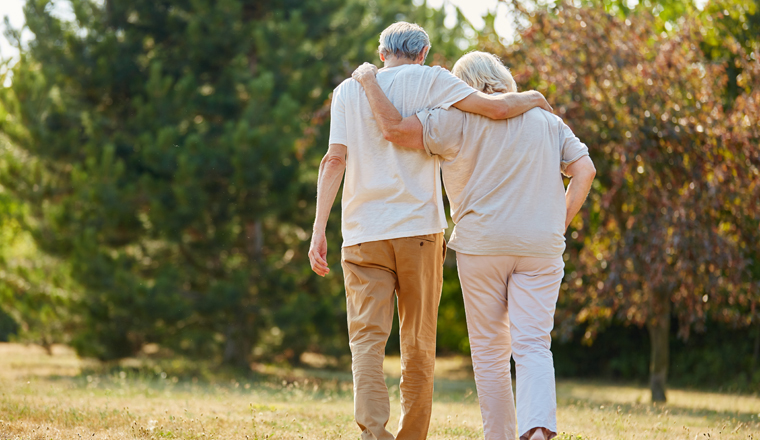 Zwei verliebte Senioren gehen spazieren im Sommer in der Natur 
