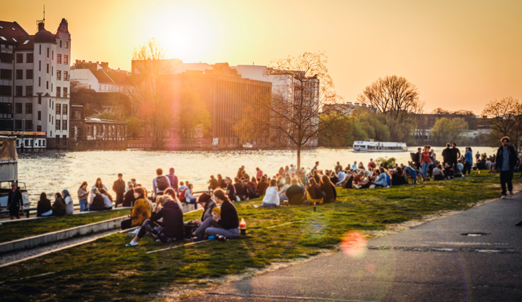 Berlin, Germany - april, 2019:  People enjoying sunset at river next to the Berlin Wall / East Side Gallery  in Berlin, Germany