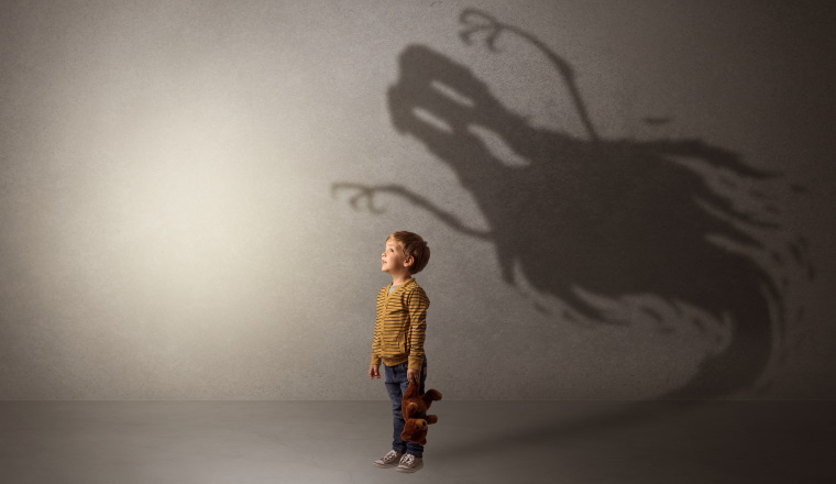 Scary ghost shadow in a dark empty room with a cute blond child